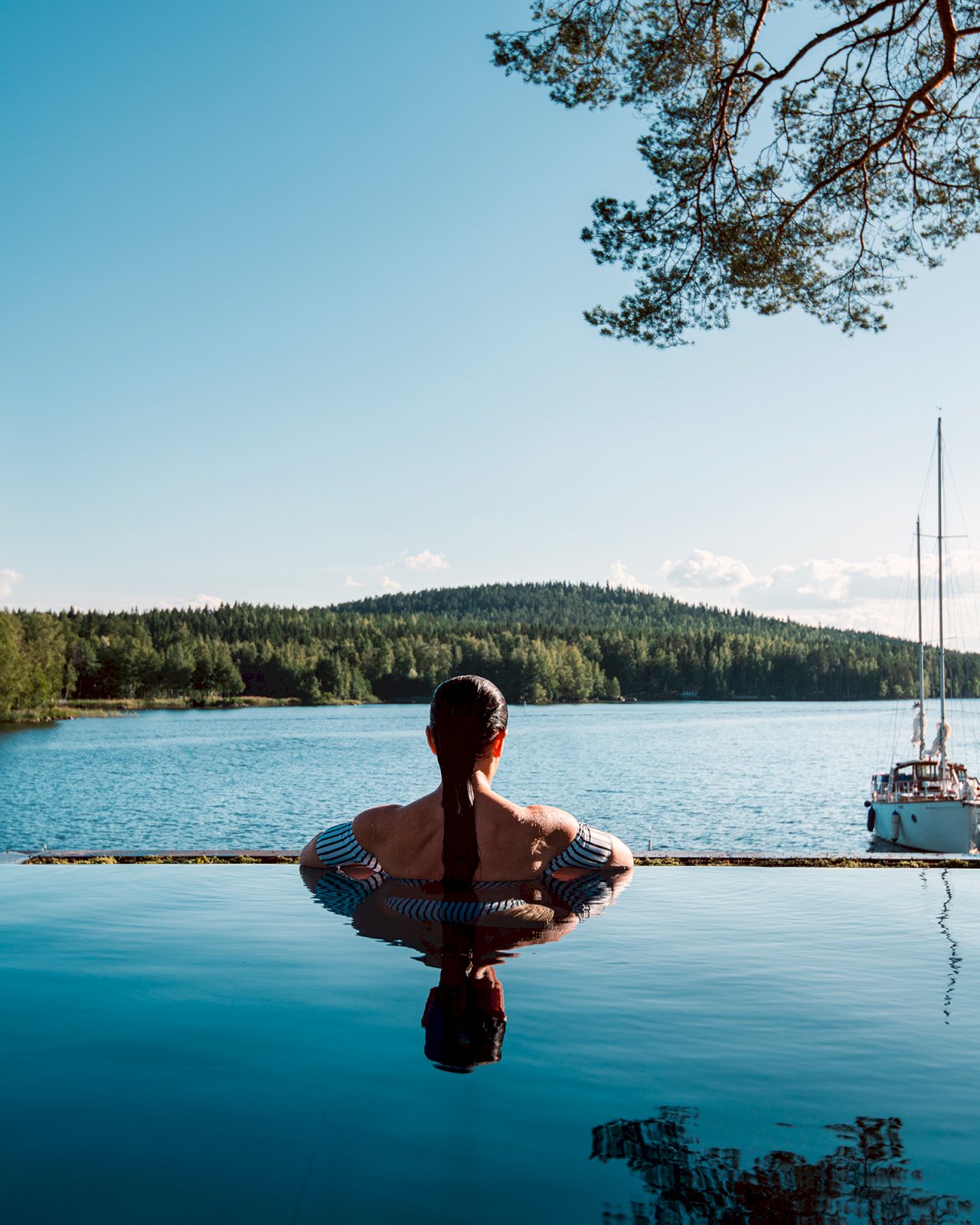 Ilola Inn -hotellin infinity-pool, josta nainen katsoo järvelle päin