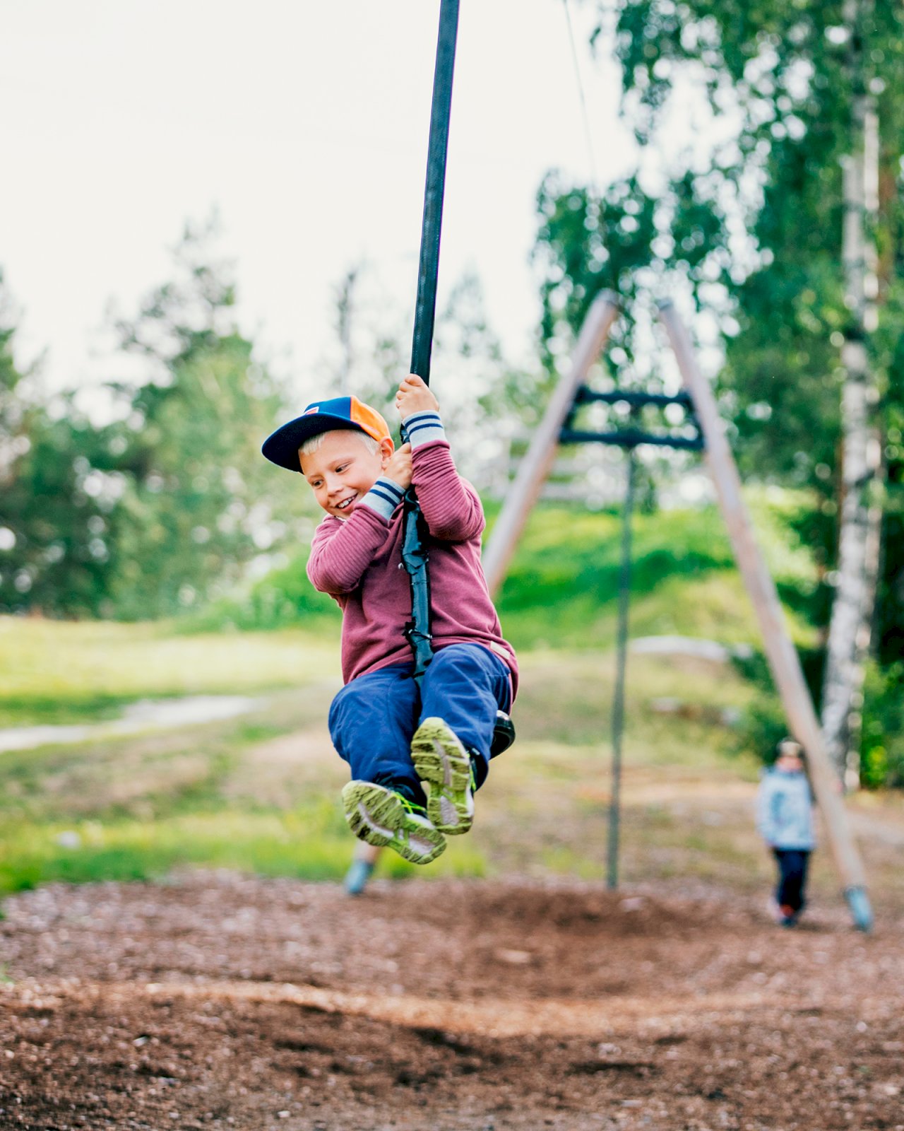 Lapsi vaijerikeinun kyydissä Luodon urheilupuistossa