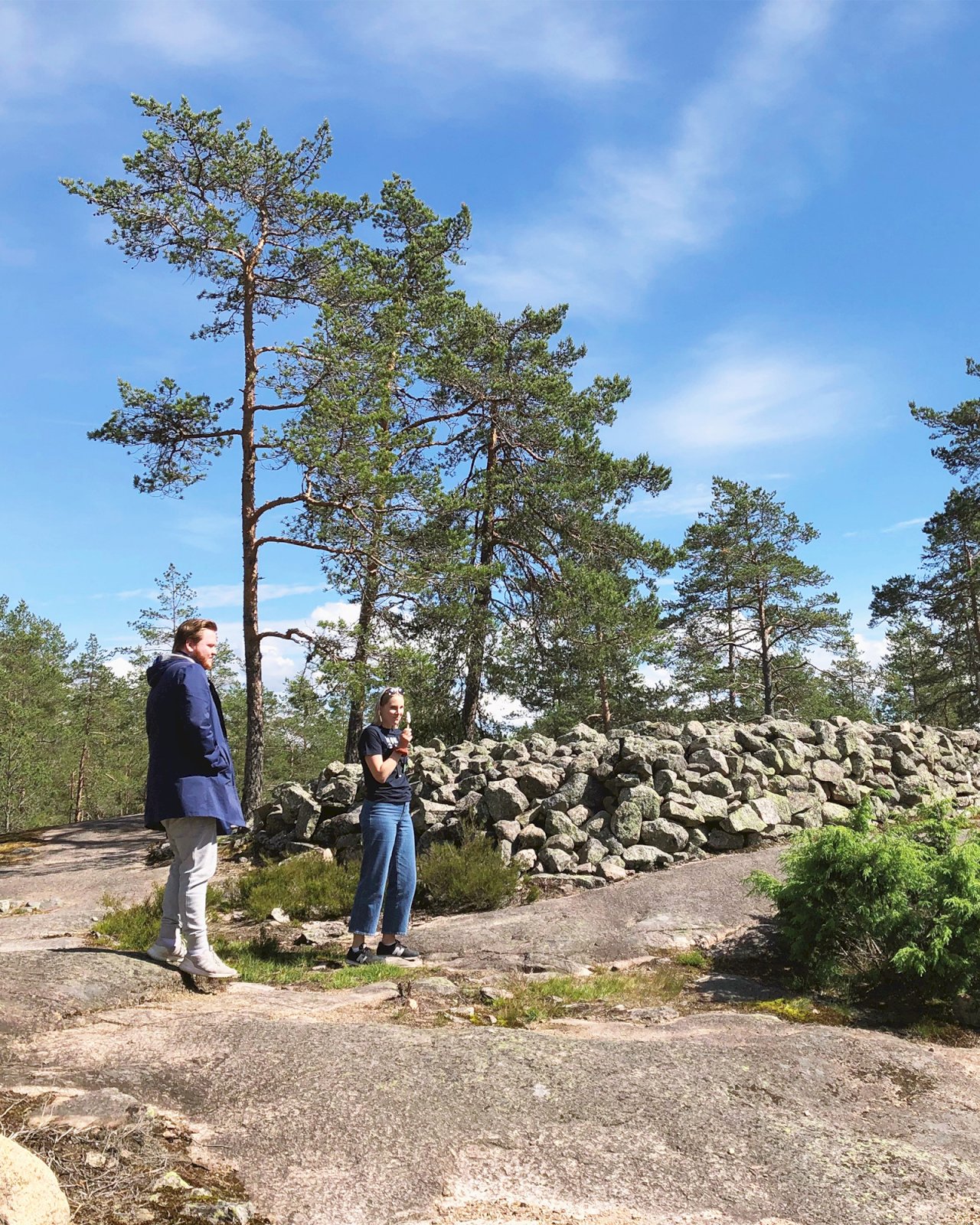 Matkailijoita Sammallahdenmäen hiidenkiukaan edustalla