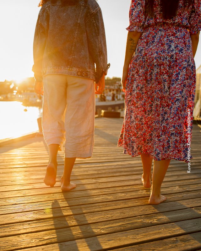 Kaksi lomailijaa satamakävelyllä Lutakon sataman laiturilla