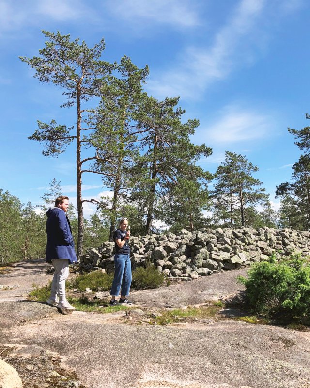 Matkailijoita Sammallahdenmäen hiidenkiukaan edustalla